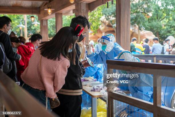 Medical workers carry out COVID-19 nucleic acid testing on tourists at Shanghai Disney Resort on October 31, 2022 in Shanghai, China. Shanghai Disney...