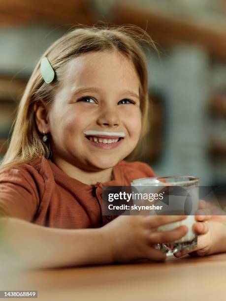 happy girl with milk mustache at home. - milk moustache stock pictures, royalty-free photos & images