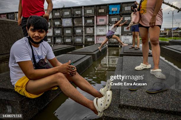 Filipinos visit departed loved ones at a flooded cemetery following Tropical Storm Nalgae, as they mark All Saints' Day on November 01, 2022 in...