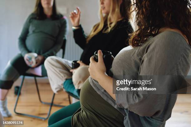 circle of pregnant women at birth preparation workshop - pregnancy class stock-fotos und bilder