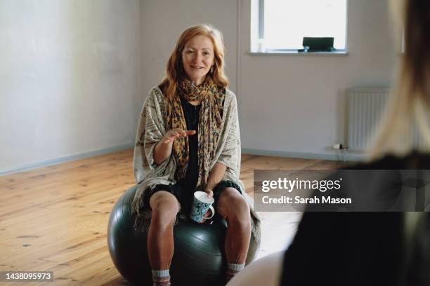 woman sat on yoga ball - yoga ball fotografías e imágenes de stock