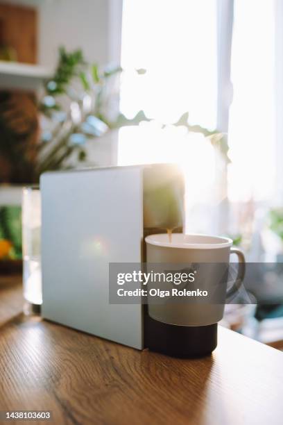 coffee capsule machine with disposable cup, preparing fresh brewed coffee drink or hot chocolate - single serve coffee maker stock pictures, royalty-free photos & images