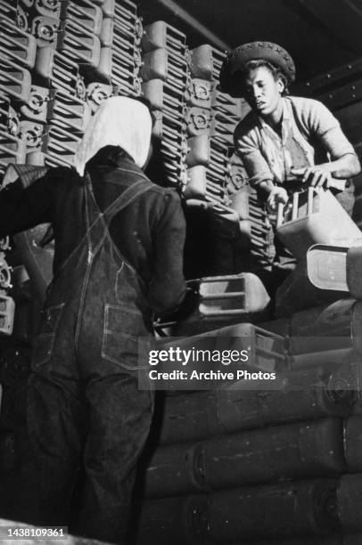 Women stacking jerrycans, employed at Savannah Quartermaster Depot in Savannah, Georgia, circa 1943.