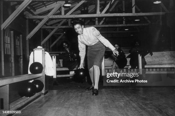 Master sergeant Helen Starr, of the Women's Army Corps Detachment, approaches the lane ready to dispatch the ball at the bowling alley at Fort...