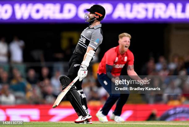 Kane Williamson of New Zealand looks dejected after losing his wicket as Ben Stokes of England is seen celebrating in the background during the ICC...