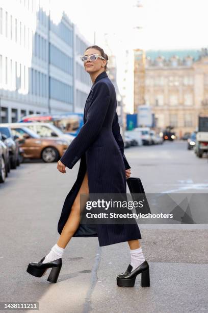 Federrock founder and influencer Anna von Schilcher, wearing a dark blue coat-dress by Sportmax, white socks by Item m6, black plateau loafers by...