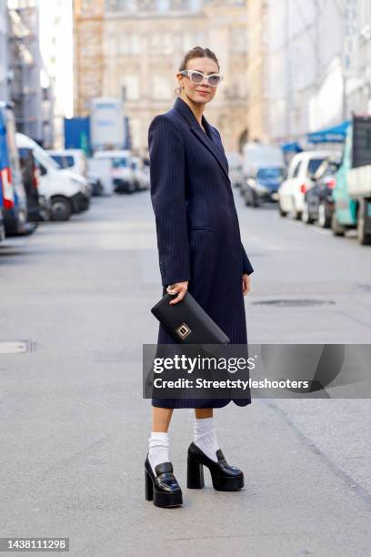 Federrock founder and influencer Anna von Schilcher, wearing a dark blue coat-dress by Sportmax, white socks by Item m6, black plateau loafers by...