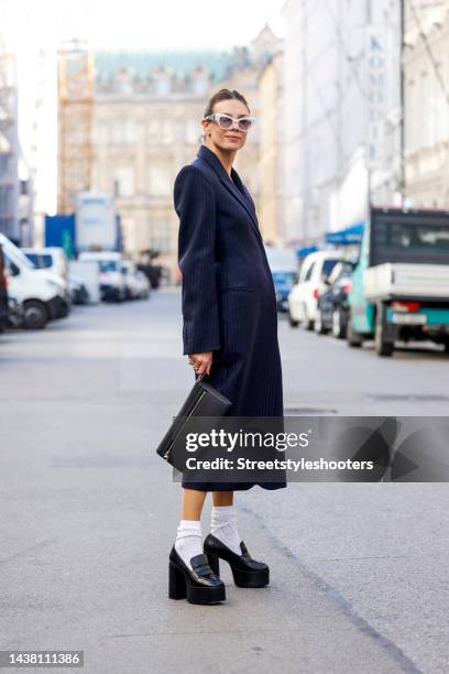 Federrock founder and influencer Anna von Schilcher, wearing a dark blue coat-dress by Sportmax, white socks by Item m6, black plateau loafers by...