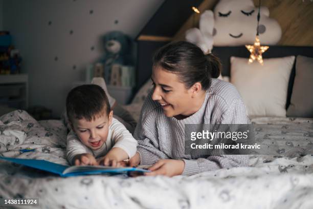 madre e hijo acostados en la cama y compartiendo amor. - 2 3 ans fotografías e imágenes de stock