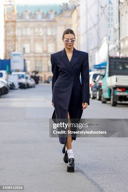 Federrock founder and influencer Anna von Schilcher, wearing a dark blue coat-dress by Sportmax, white socks by Item m6, black plateau loafers by...