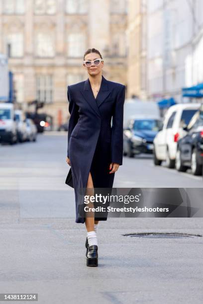 Federrock founder and influencer Anna von Schilcher, wearing a dark blue coat-dress by Sportmax, white socks by Item m6, black plateau loafers by...
