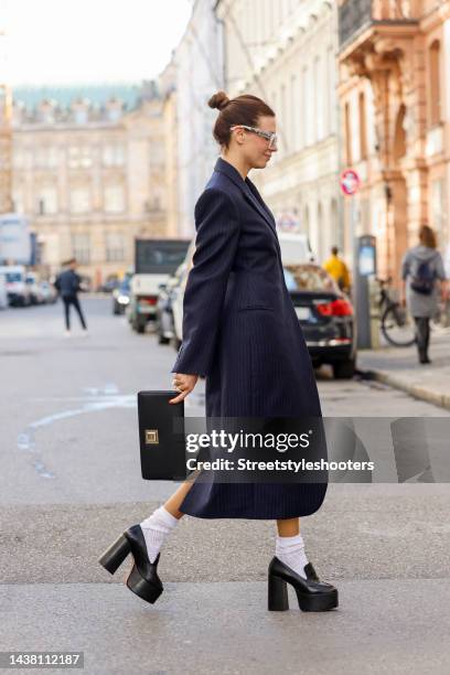 Federrock founder and influencer Anna von Schilcher, wearing a dark blue coat-dress by Sportmax, white socks by Item m6, black plateau loafers by...