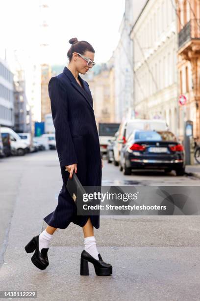 Federrock founder and influencer Anna von Schilcher, wearing a dark blue coat-dress by Sportmax, white socks by Item m6, black plateau loafers by...