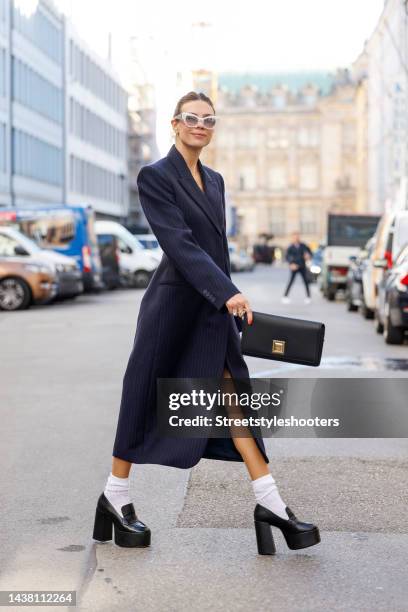 Federrock founder and influencer Anna von Schilcher, wearing a dark blue coat-dress by Sportmax, white socks by Item m6, black plateau loafers by...