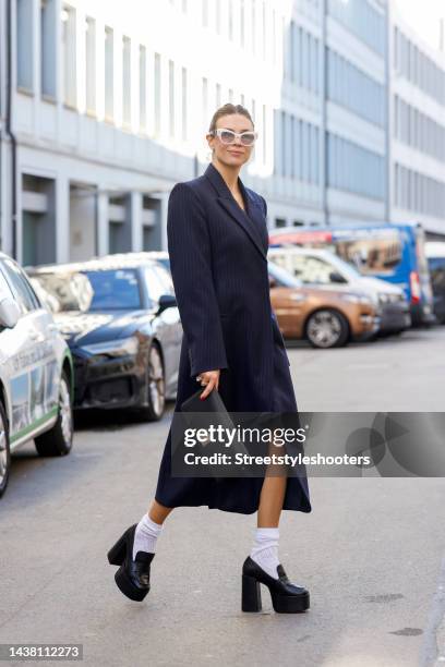 Federrock founder and influencer Anna von Schilcher, wearing a dark blue coat-dress by Sportmax, white socks by Item m6, black plateau loafers by...