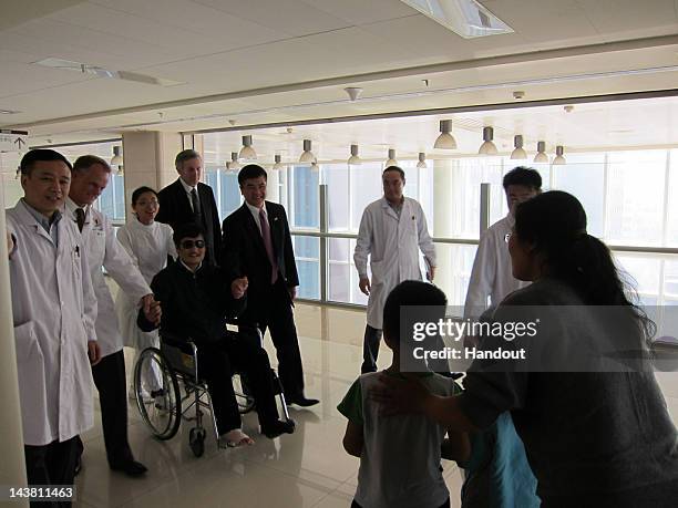 In this handout photograph provided by the U.S. Embassy Beijing press office, Chinese dissident Chen Guangcheng , holding hands with U.S. Ambassador...