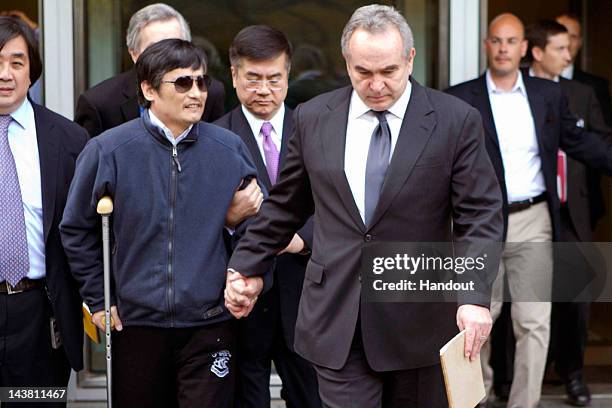 In this handout photograph provided by the U.S. Embassy Beijing press office, Chinese dissident Chen Guangcheng holds hands with Assistant Secretary...