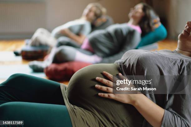 pregnant women lying down meditating in pre-natal class - yoga prop stock pictures, royalty-free photos & images