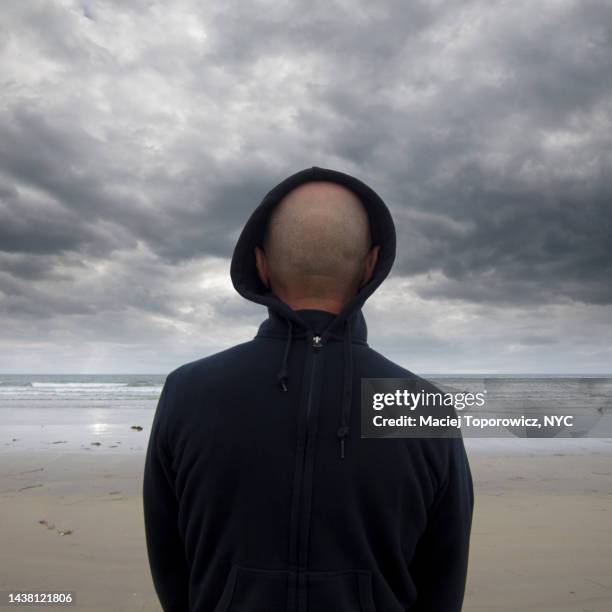 portrait of a man in hood on the beach - blind man stock pictures, royalty-free photos & images