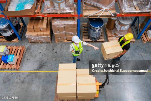 top view of two asian warehouse worker working with digital tablet and laptop in the warehouse. - busy warehouse stock pictures, royalty-free photos & images