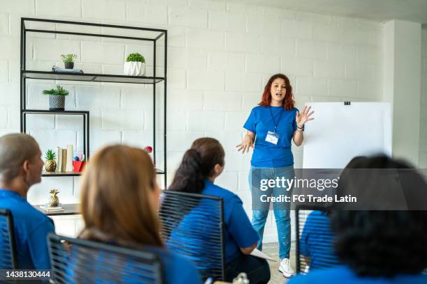 volunteer woman showing her ideas and plans on a community center - employee welfare stockfoto's en -beelden