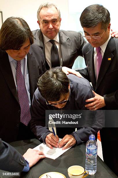 In this handout photograph provided by the U.S. Embassy Beijing press office, Chinese dissident Chen Guangcheng is assisted by U.S. Ambassador to...