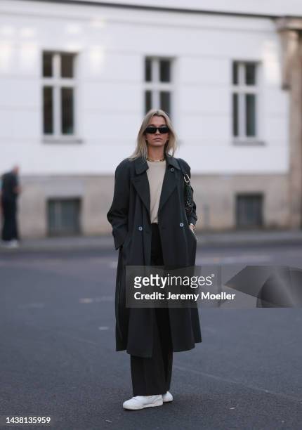 Luise Neck seen wearing New Balance 550 white sneaker, a Furla bag, Prada shades, a vintage olive coat, vintage brown pants and an About You beige...