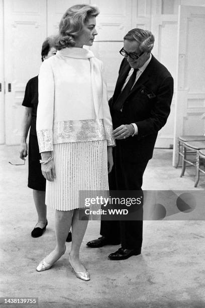 Lauren Bacall with Norman Norell trying on her Spring wardrobe at the designer's showroom.