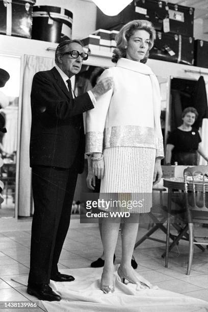 Lauren Bacall with Norman Norell trying on her Spring wardrobe at the Norell showroom in New York