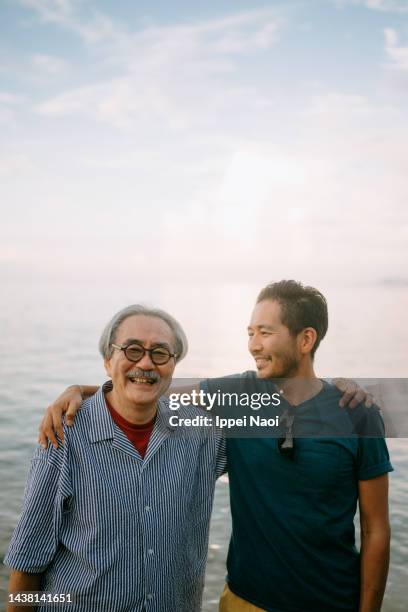 senior father and adult son having fun on beach at sunset, japan - only japanese bildbanksfoton och bilder