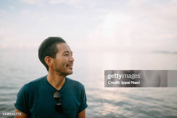 man contemplating on beach at sunset - looking away stock pictures, royalty-free photos & images