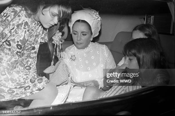 Elizabeth Taylor in car with daughters Liza Todd, Maria and Kate Burton, arriving by ship in New York