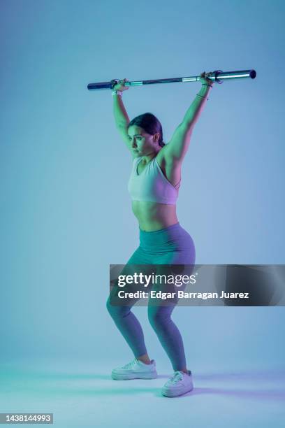 young latin woman, with sportswear in photo session, lifting with a gym bar - mexico training session stock pictures, royalty-free photos & images