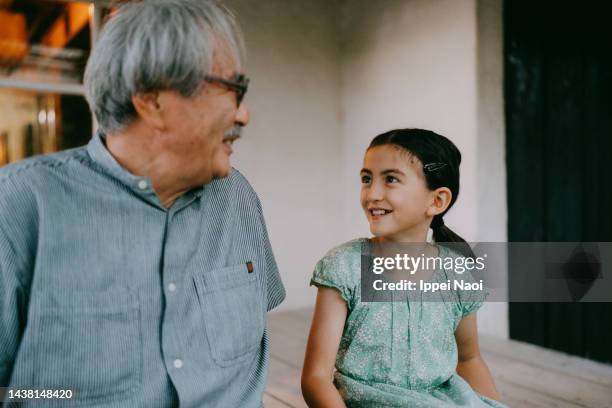 grandfather and granddaughter talking on porch - granddaughter stock pictures, royalty-free photos & images