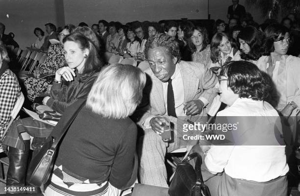Outtake; Gordon Parks with a drink, seated in the crowd at Gloria Vanderbilt's 1970 show..Article title: "Gloria Vanderbilt: Making waves"
