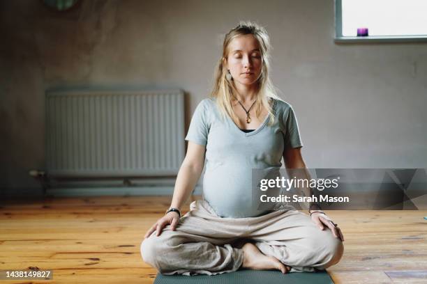 pregnant woman with blonde hair sat meditating - yoga prop stock pictures, royalty-free photos & images