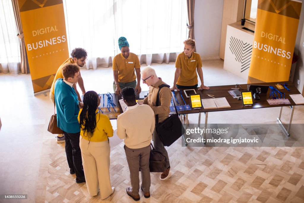 Business conference participants registering for a conference in the lobby of a luxury hotel