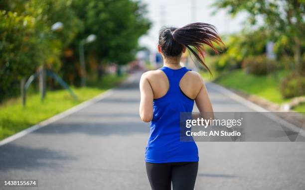 back view of young fitness sports women runner running in the park. healthy fitness woman jogging outdoors. sport and health concept - woman walking studio back stock pictures, royalty-free photos & images