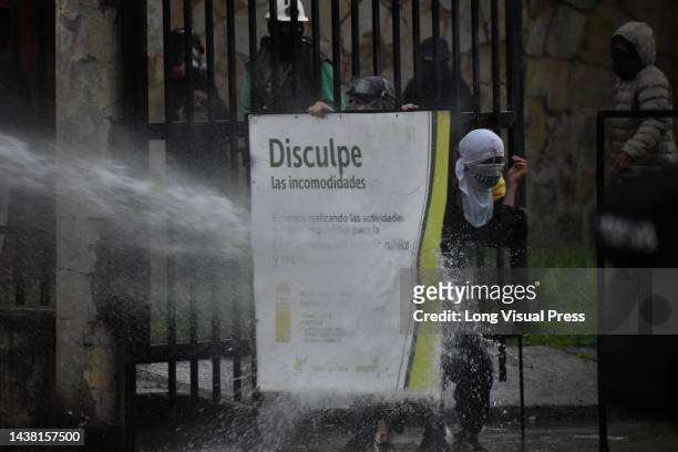 Demonstrator is hit with a water canon from a riot tank as protests rise in Bogota, Colombia amid the liberation of political prisoners captured...
