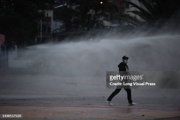Demonstrator standing in water being fired from a water canon riot tank as protests rise in Bogota, Colombia amid the liberation of political...