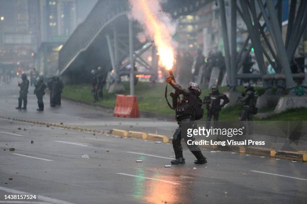 An officer from Colombia's anti-riot police squadron formerly known as ESMAD fires a tuffly tear gas shotgun as protests rise in Bogota, Colombia...