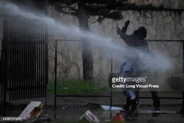 Demonstrator is hit with a water canon from a riot tank as protests rise in Bogota, Colombia amid the liberation of political prisoners captured...