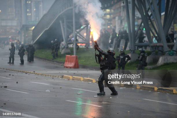 An officer from Colombia's anti-riot police squadron formerly known as ESMAD fires a tuffly tear gas shotgun as protests rise in Bogota, Colombia...