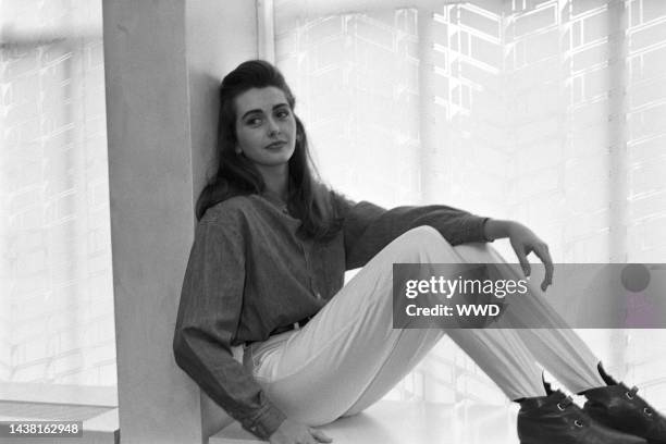 Woman modeling Guess? Jeans button-down shirt and stirrup pants.