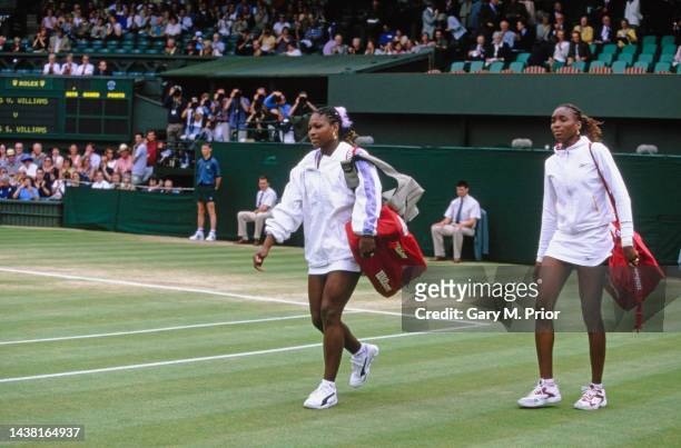Sisters Serena and Venus Williams from the United States walk onto Centre Court for their Women's Singles Semifinal match at the Wimbledon Lawn...