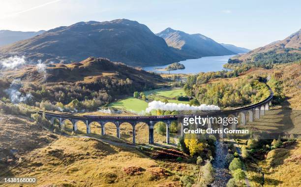 The Jacobite Steam Train crosses the Glenfinnan Viaduct on October 18,2022 in Glenfinnan, Scotland. It appeared in 3 of the films in the Harry Potter...