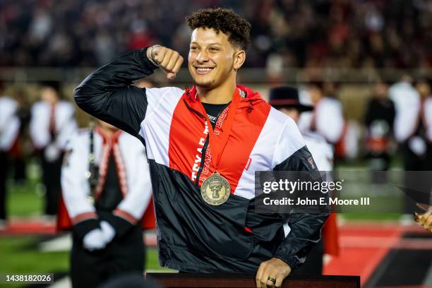 Patrick Mahomes flexes as he is inducted into the Texas Tech Hall of Fame and Ring of Honor during halftime of the game between the Texas Tech Red...