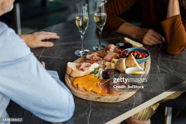 sharing a charcuterie board - cheese and champagne stock pictures, royalty-free photos & images