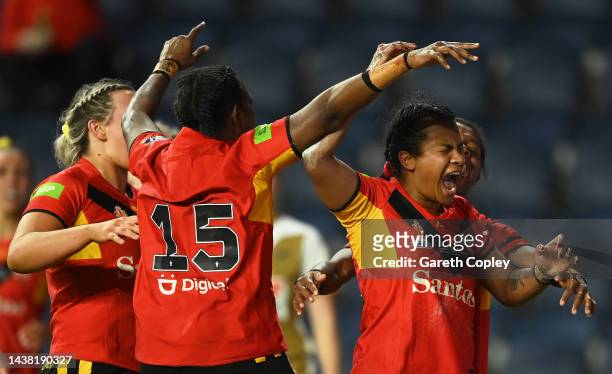Ua Ravu of Papua New Guinea celebrates with teammates after scoring their team's fourth try during the Women's Rugby League World Cup Group A match...