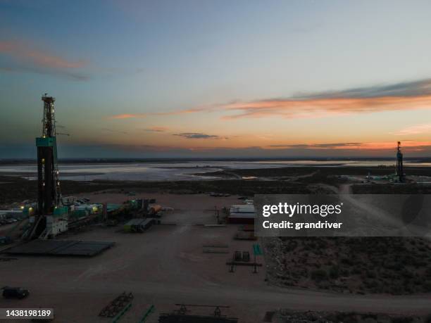 sunset shot of an oil fracking drill rig under dramatic sunset sky in the permian basin in west texas or new mexico - recycling rig imagens e fotografias de stock